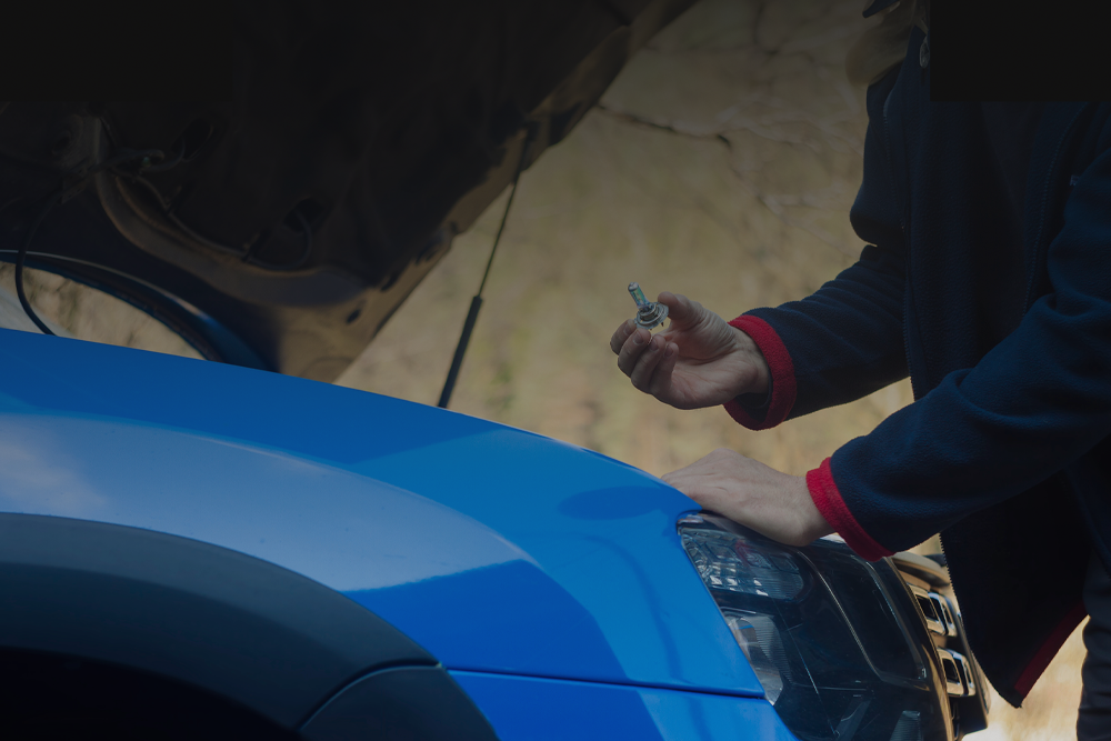 a person replacing the headlight bulb in a vehicle